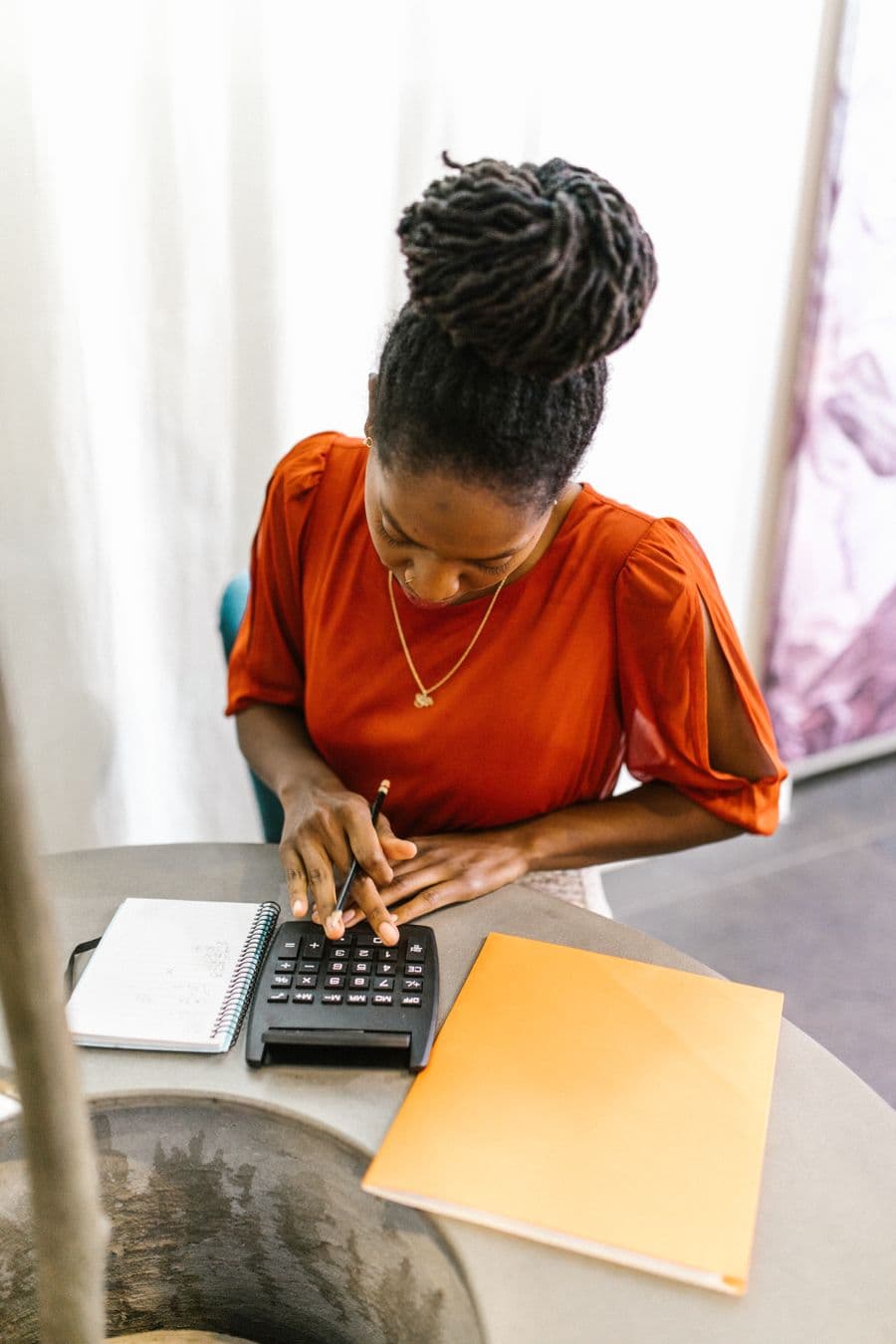 A professional reviewing figures with a calculator and documents